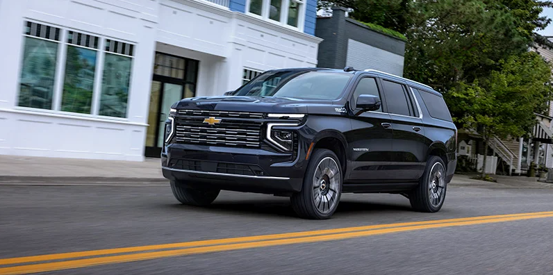 A black 2025 Chevy Suburban driving down the road.